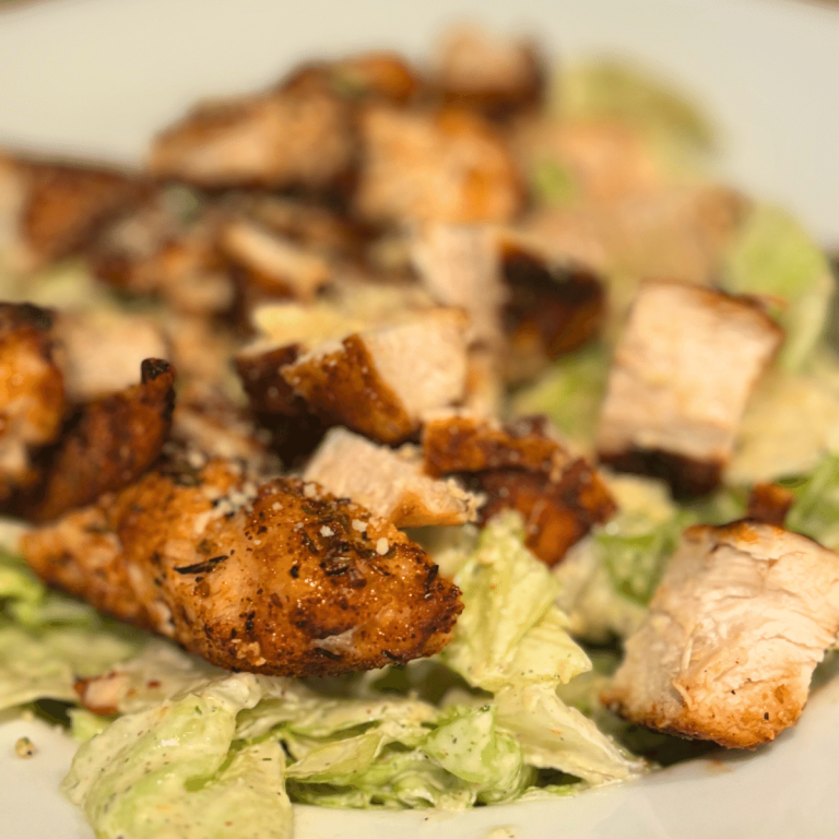Up close shot of a bowl Cajun chicken Caesar Salad.