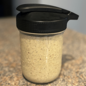 Mason jar with Creamy Caesar Dressing and a flip top lid.