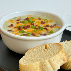 Bowl of creamy potato soup with crusty bread on the side.