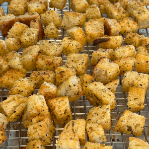 Italian seasoned sourdough croutons on a cooling rack.