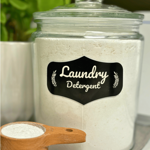 Glass jar full of homemade non-toxic laundry detergent with wooden measuring cup.