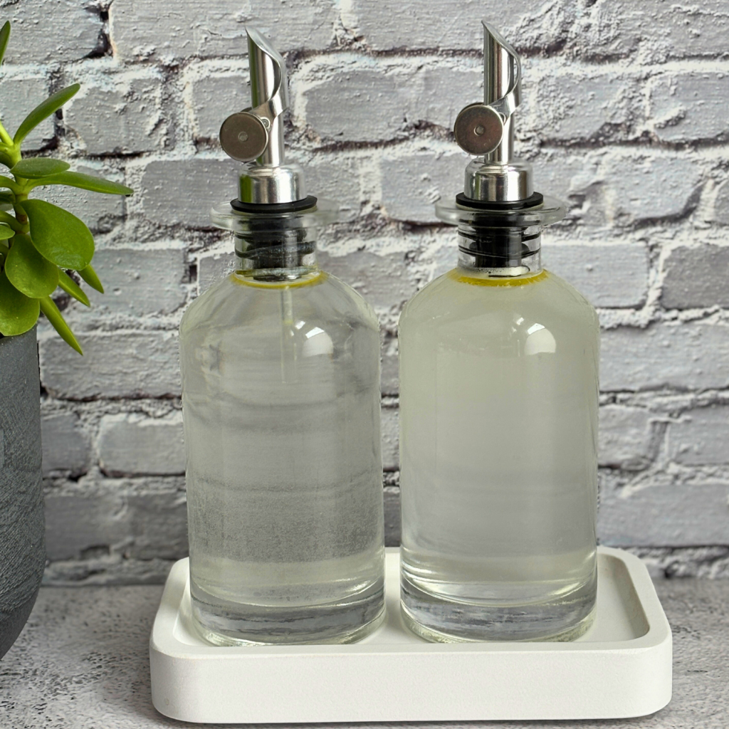 Two glass bottles full of homemade non-toxic rinse aid.