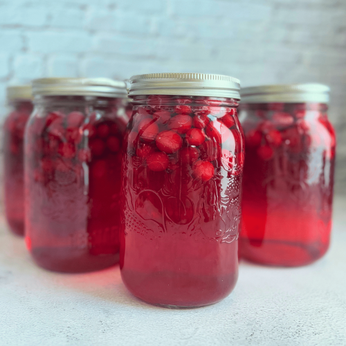 Jars of Canned Cranberry Juice on a counter.