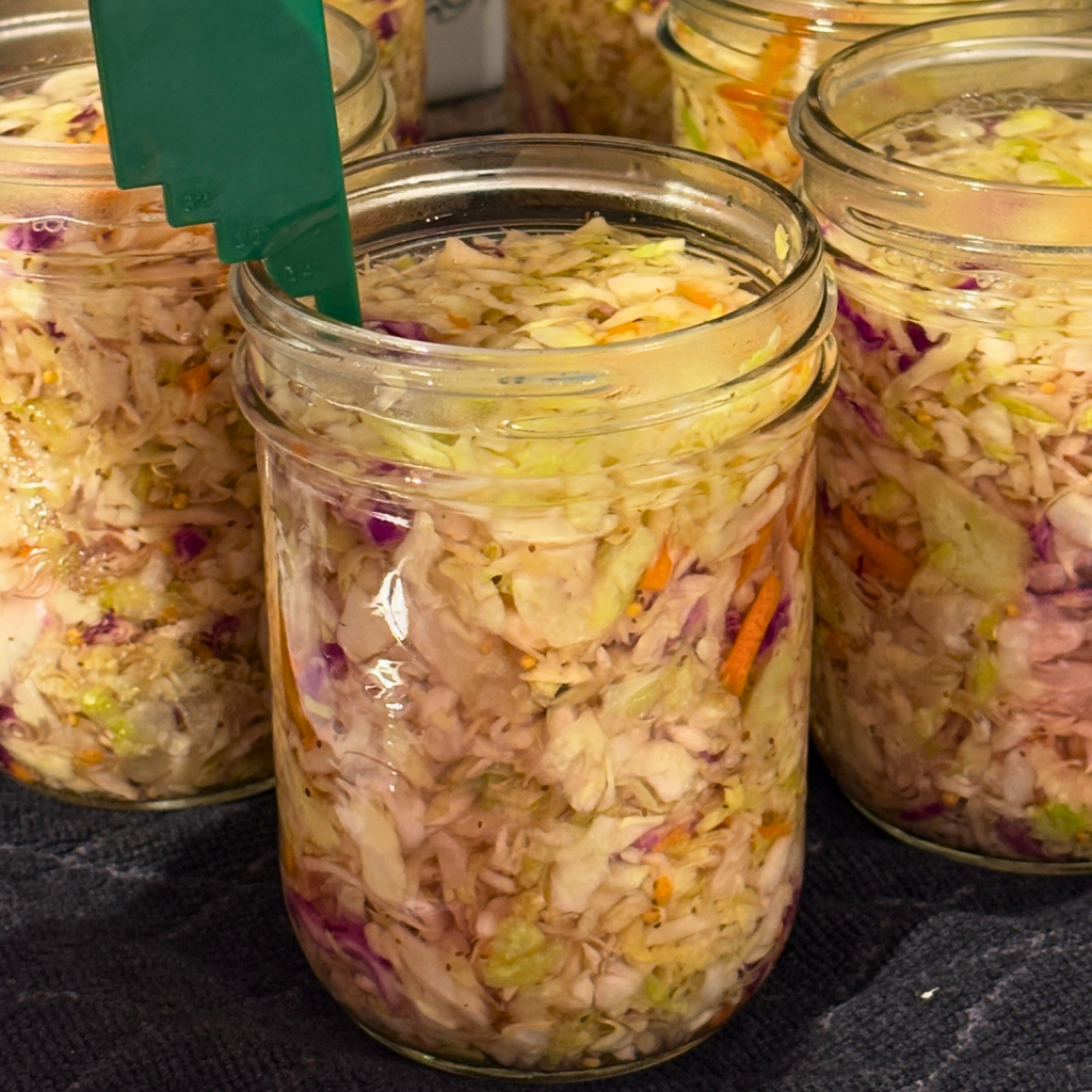 Filling jars of canned coleslaw recipe to 1/2 inch headspace.