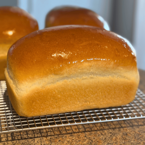 Three fresh loaves of bread with buttered tops