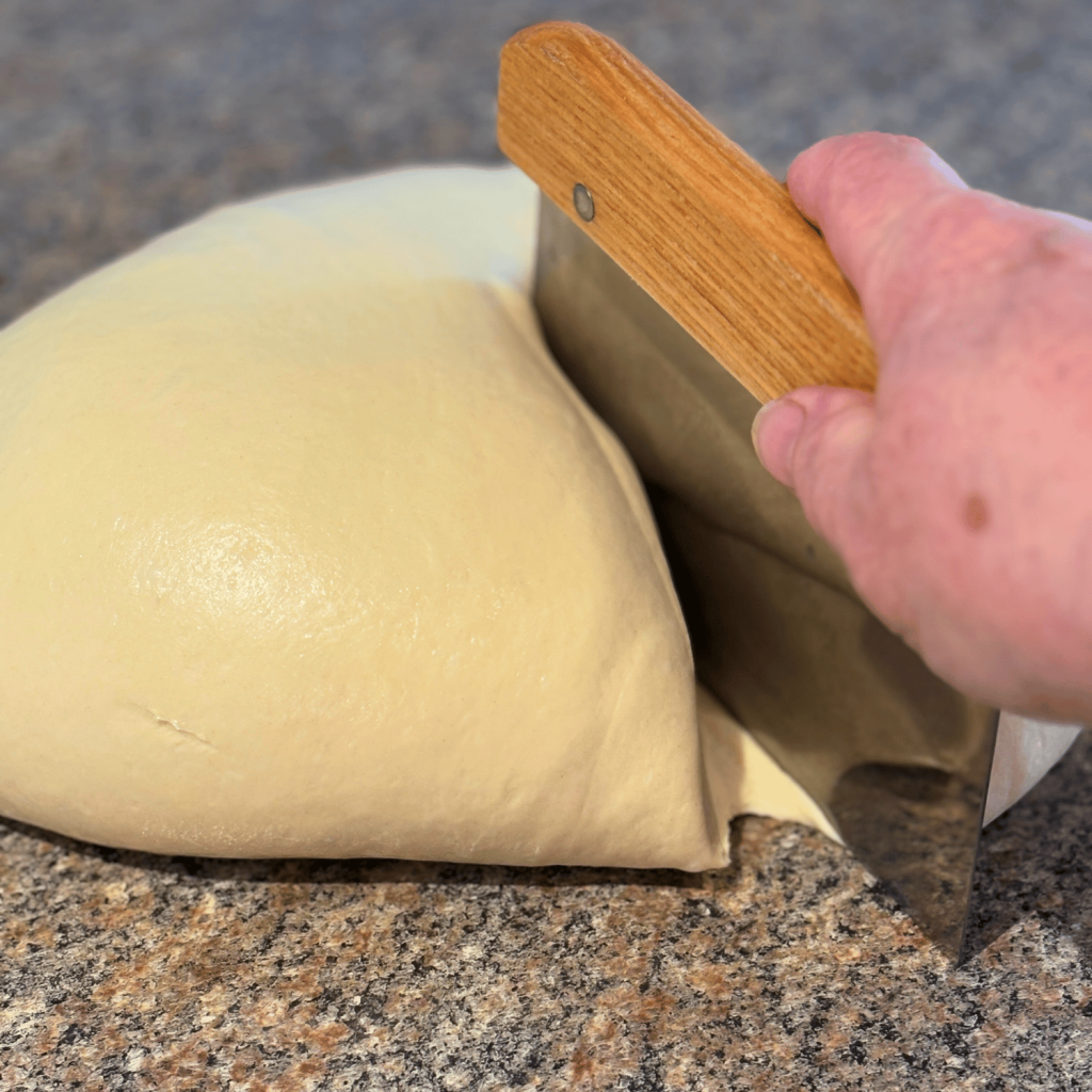 Cutting bread dough with a bench knife