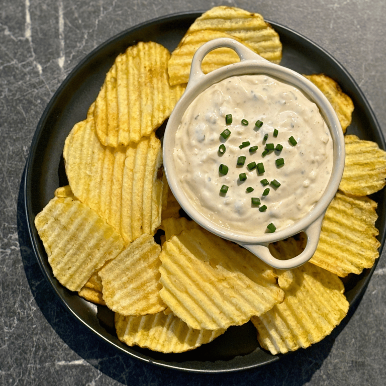 bowl with onion dip on a plate surrounded by Ripple Chips