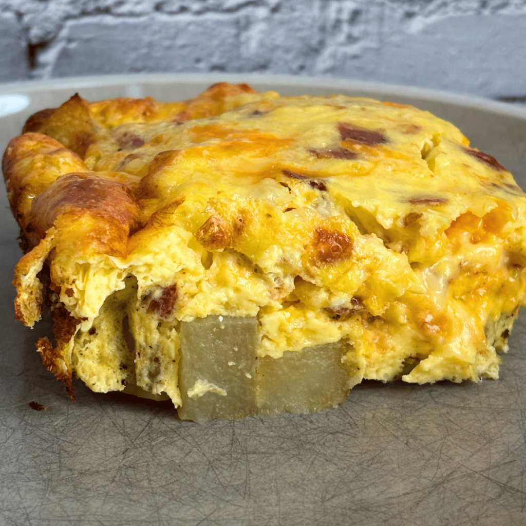 Piece of breakfast casserole with potatoes and bacon