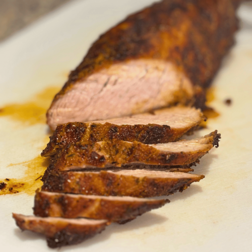 Sliced air fried pork tenderloin on a cutting board