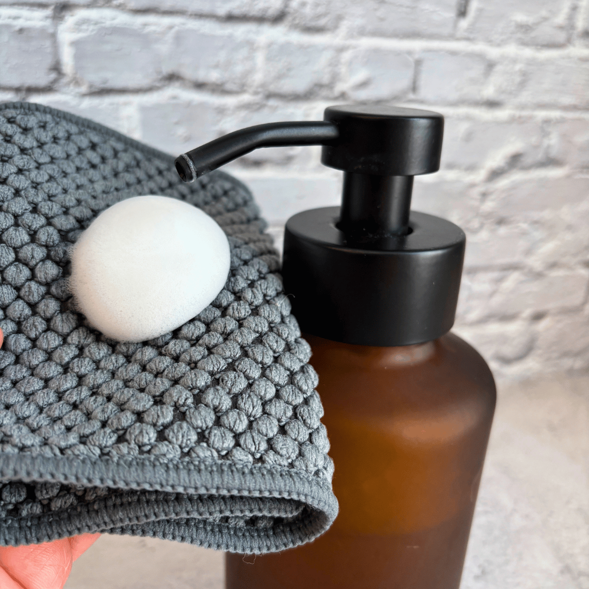 bottle of hand soap foaming onto a cloth