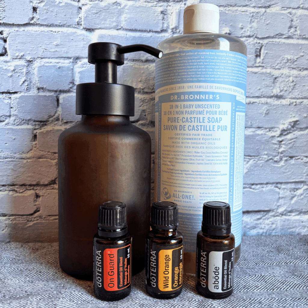 Glass foaming hand soap bottle, pure castile soap and three essential oils bottles.