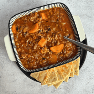 Bowl of Lentil and Wild Rice Soup with crackers on the side.