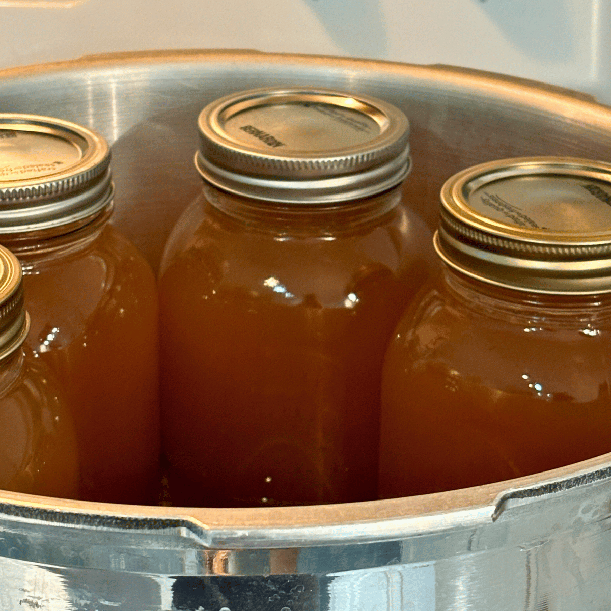 Quart jars of homemade chicken bone broth in a canner