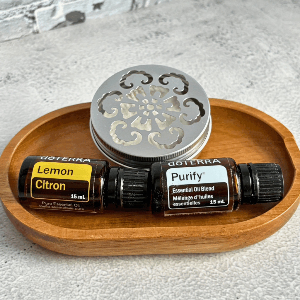 Deodorizing disk on wooden dish next to doTERRA Lemon and Purify EO.