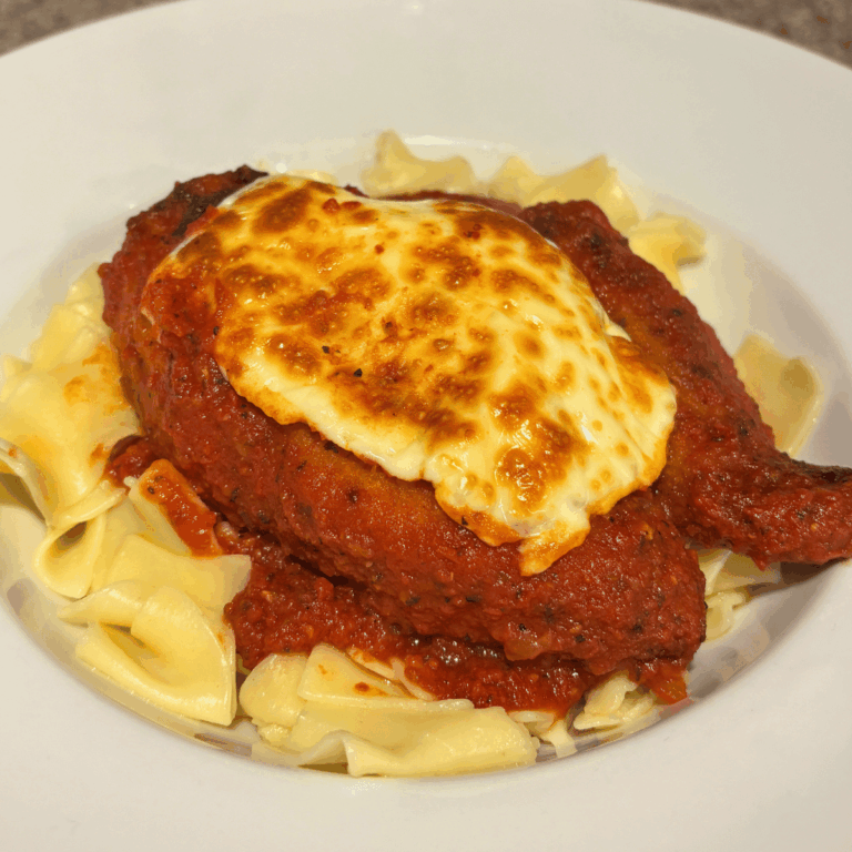 Chicken parmesan on a bed of egg noodles.