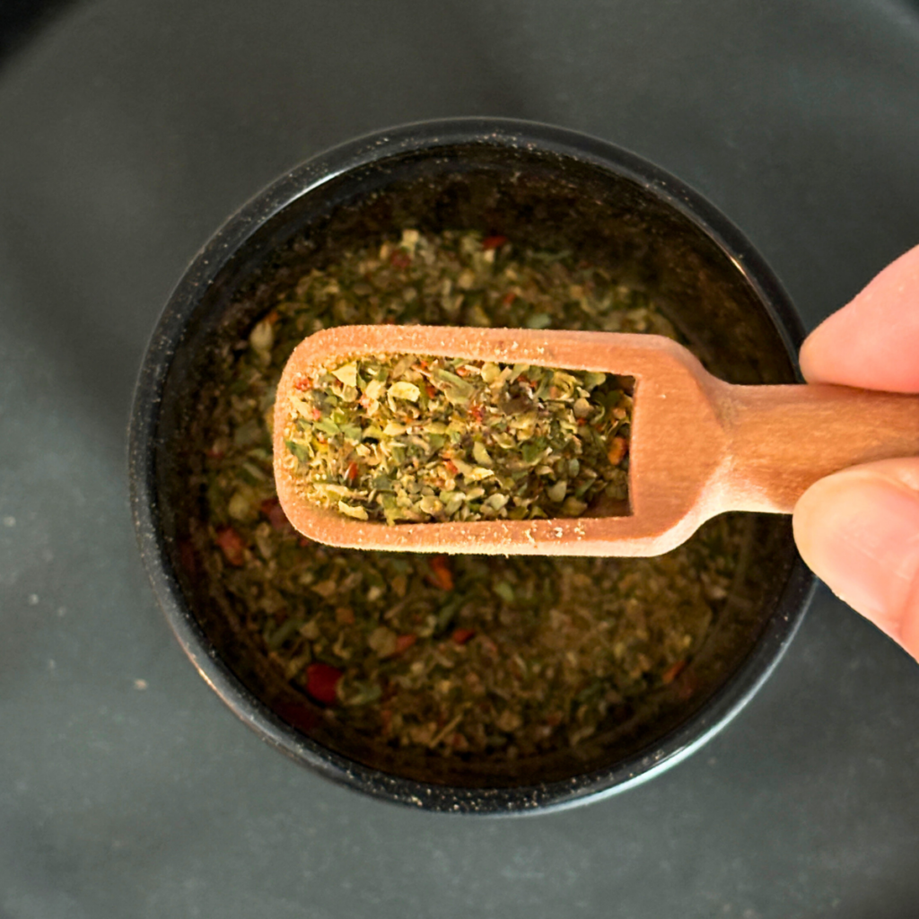 A scoop full of homemade Greek seasoning.