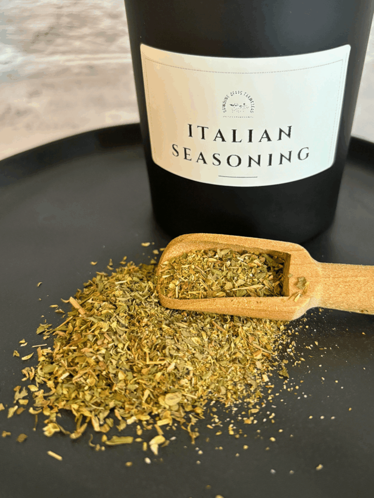 Italian Seasoning in a wooden scoop on a black plate
